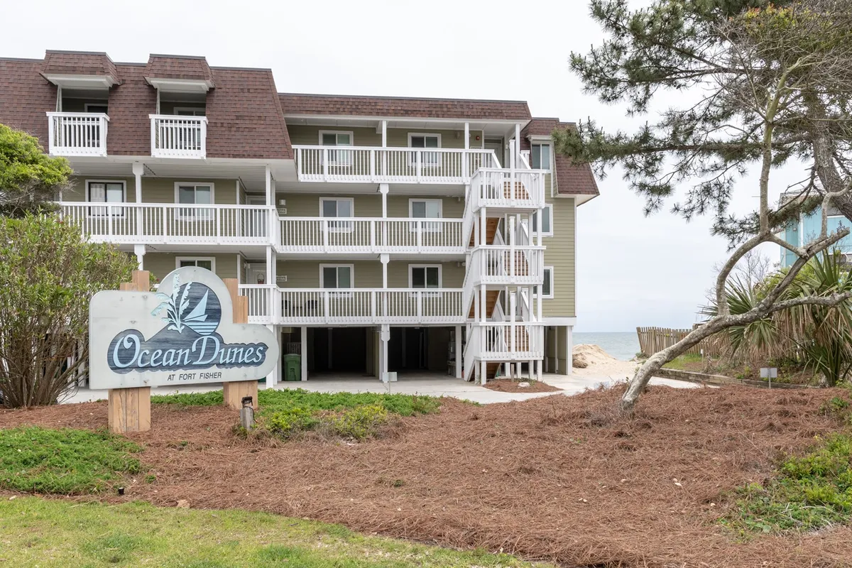 This image features the Ocean Dunes sign, the main building facade, and lush surrounding greenery, clearly situating the property in its coastal environment. The resort’s welcoming exterior and visible proximity to nature set the scene for effortless family access to beach adventures and local attractions.